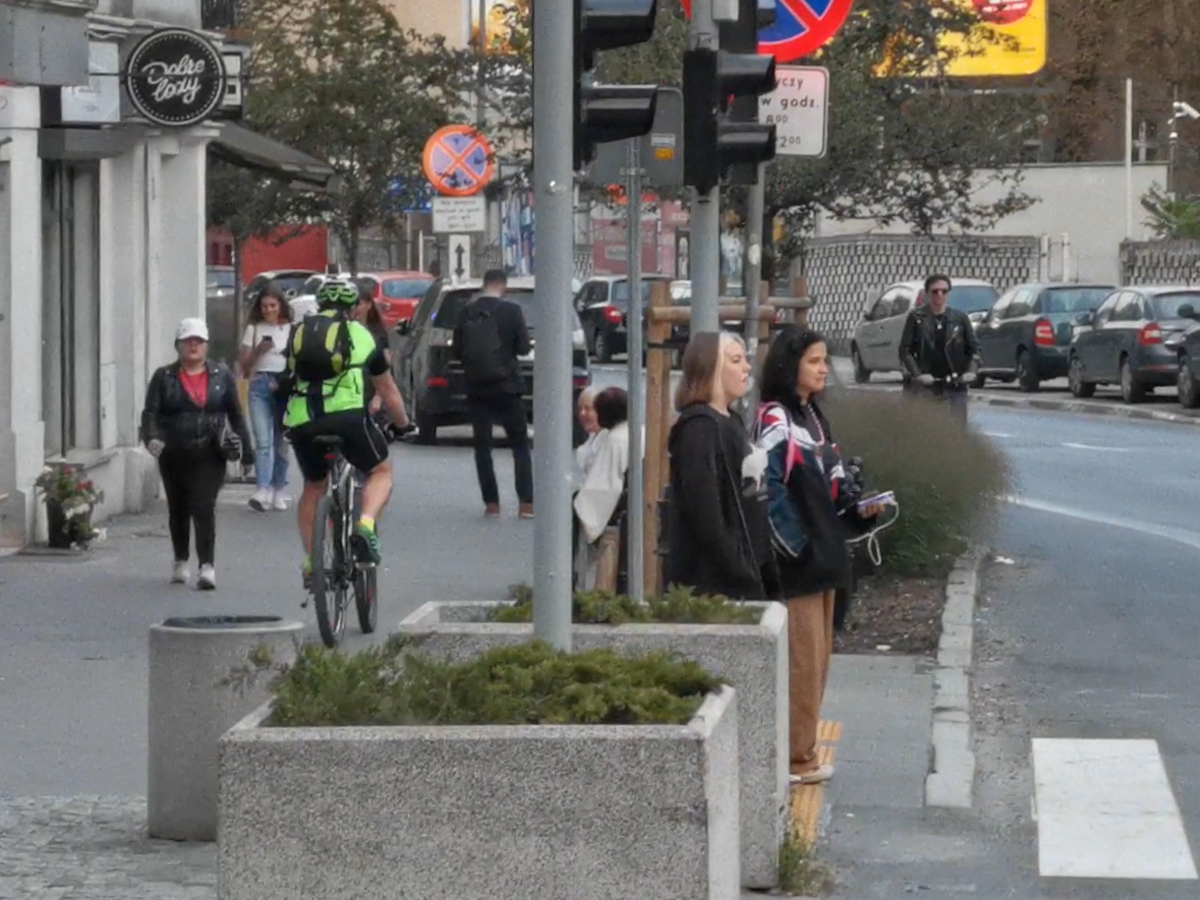 Ulica Krakowska. Rowerzysta jedzie chodnikiem. Z prawej strony ma jezdnię z pasem rowerowym