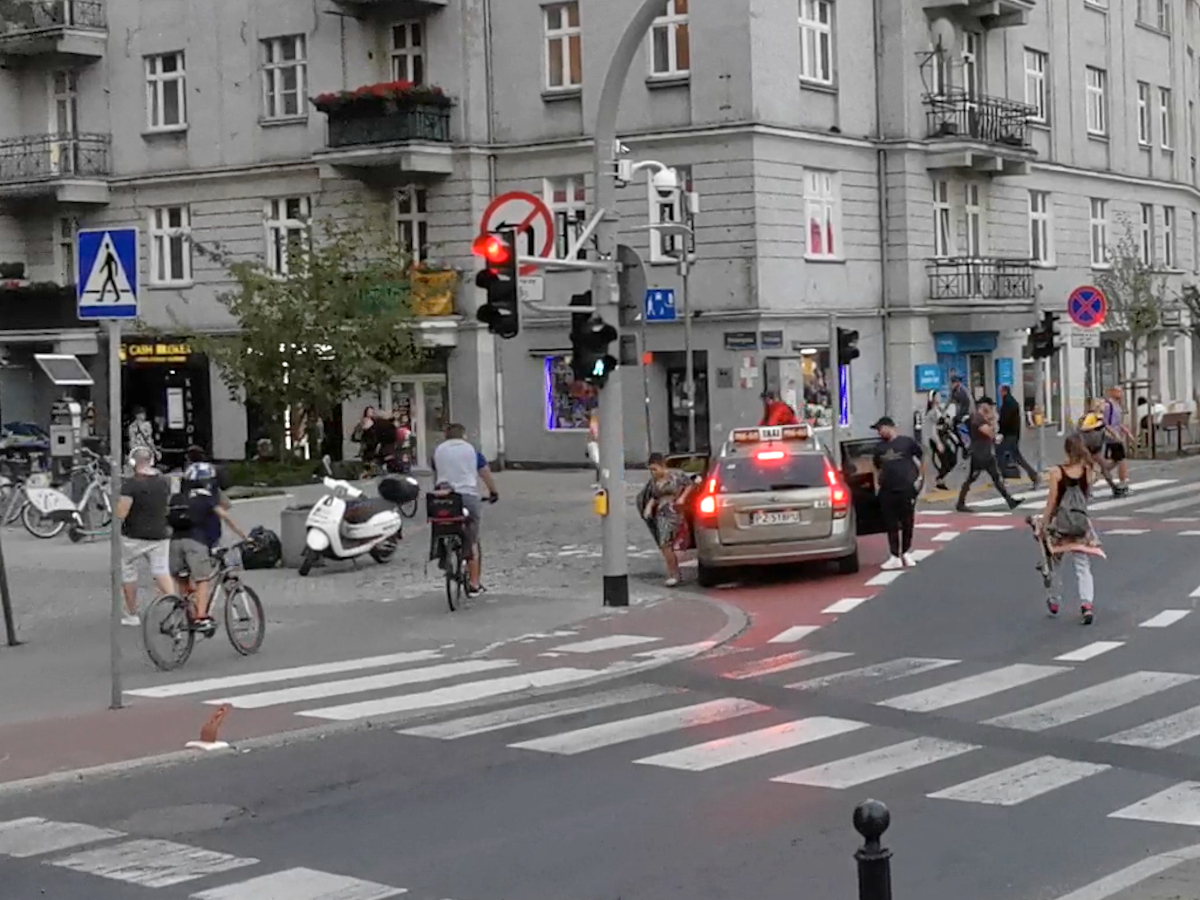 Rowerzyści wjeżdżają "na czerwonym", a taksówkarz swoim zatrzymaniem się blokuje im przejazd