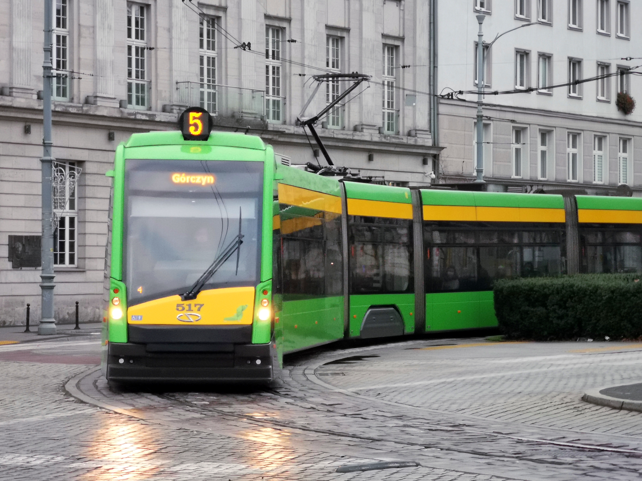 Tramwaj Solaris Tramino odjeżdża z przystanku "Marcinkowskiego" i wjeżdża na plac Wolności (pojazd MPK Poznań), pogoda pochmurna